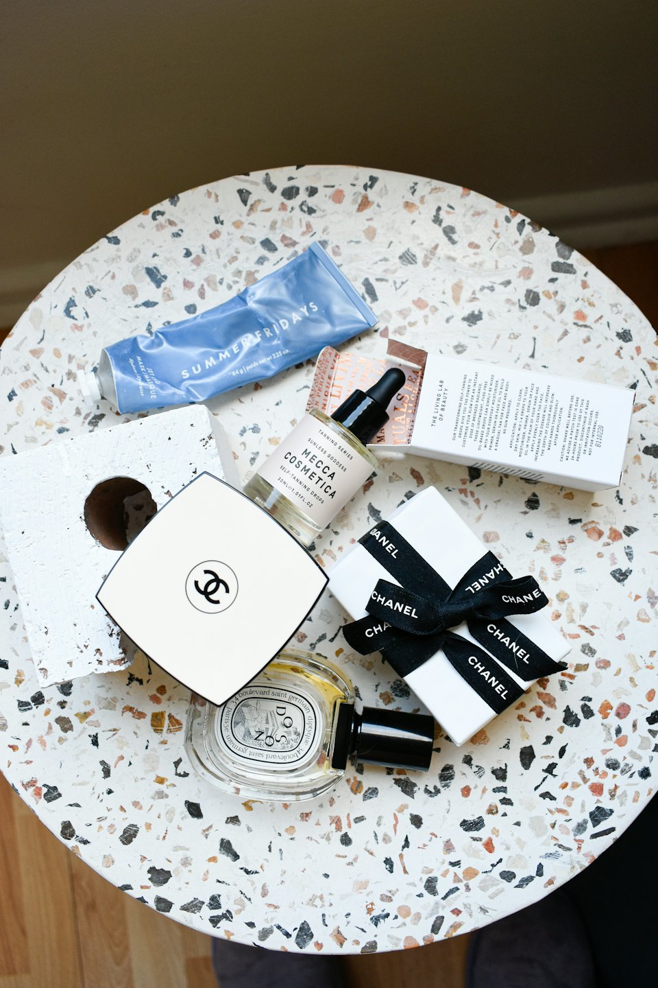 Premium beauty products arranged on a terrazzo table.